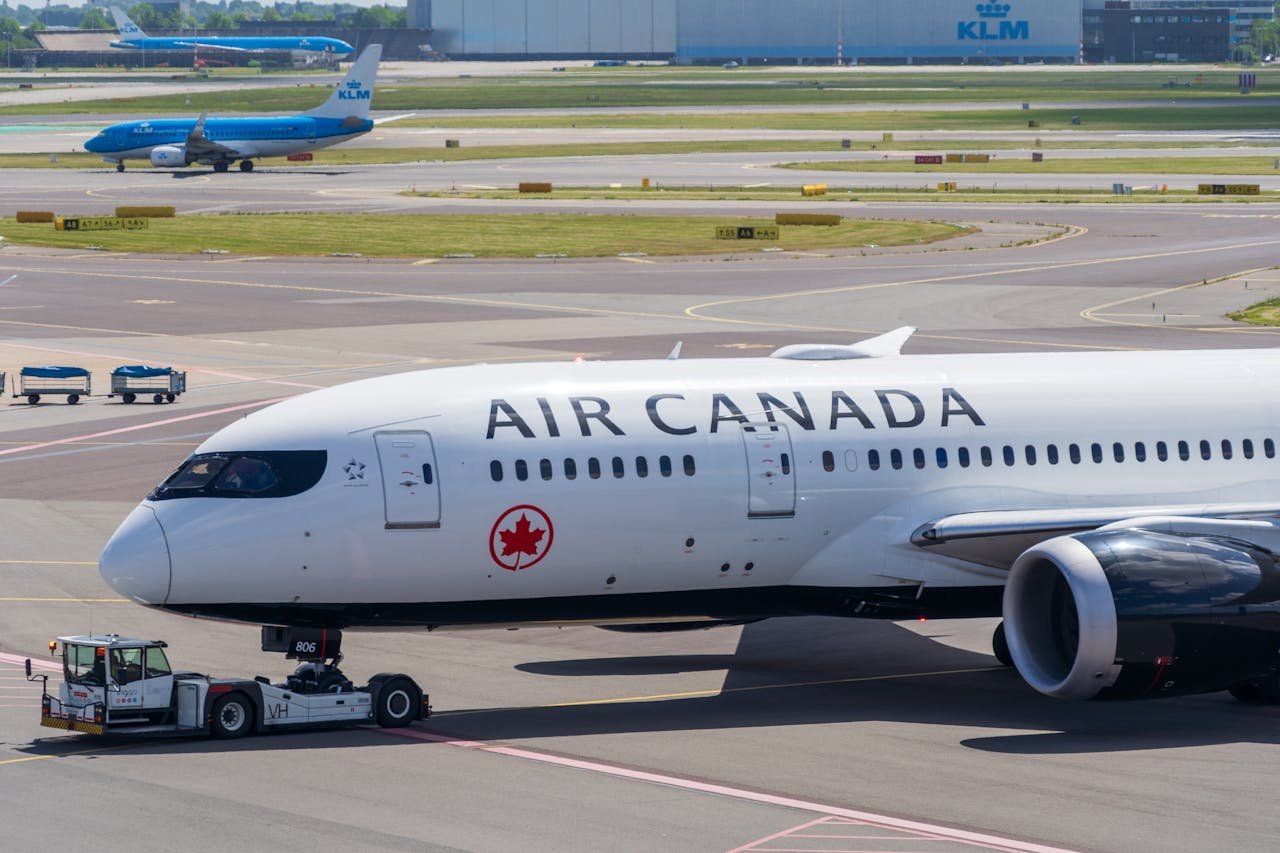 Air Canada Boeing 787 Dreamliner on the airport tarmac during a sunny day.